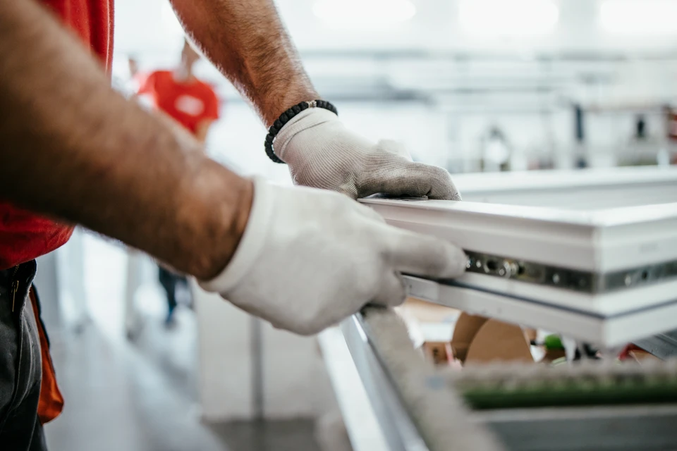 Atelier de menuiserie avec femme artisane souriante travaillant le bois à l'établi