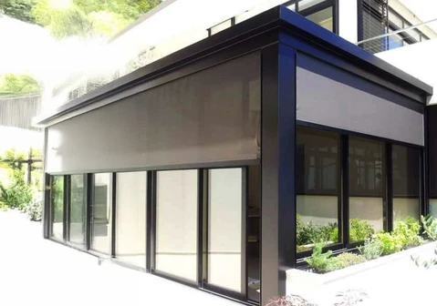 Extérieur d'un bâtiment commercial moderne avec grandes baies vitrées et store banne déployé