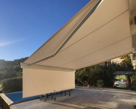Terrasse extérieure avec store banne beige déployé au-dessus d'une piscine