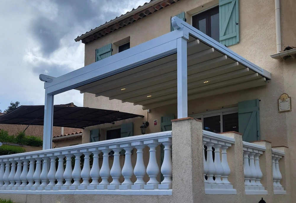 Salon moderne avec grandes baies vitrées coulissantes ouvrant sur terrasse avec pelouse artificielle