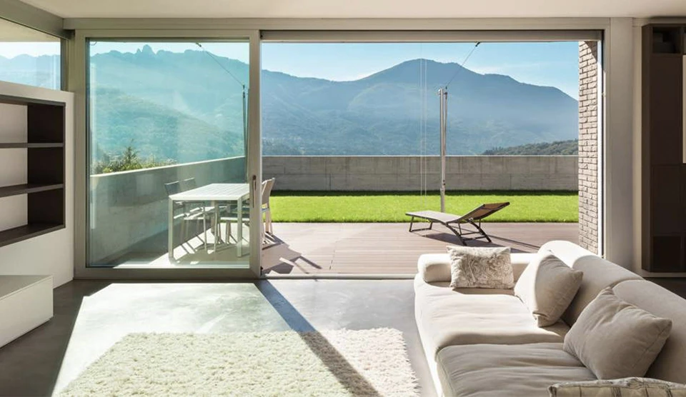 Salon moderne avec canapé orange, fauteuils beiges, coussins verts et bleus marine